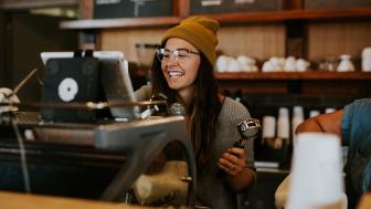 Onderneemster schenkt koffie in haar coffee bar