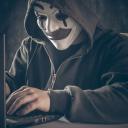 Cybercrimineel met masker achter de laptop
