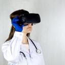 Onderzoekster met witte jas en stethoscoop werkt met een VR-bril op het hoofd