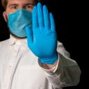 Dokter met mondmasker en handschoenen zegt stop